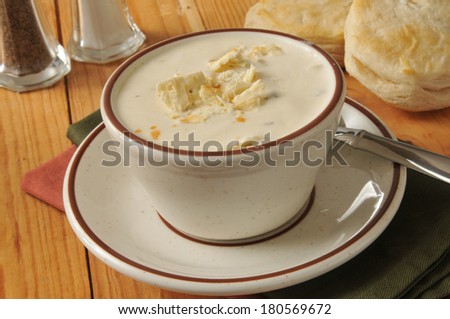 A cup of clam chowder with fresh baked biscuits