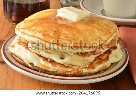 Closeup of buttermilk pancakes with melted butter and syrup