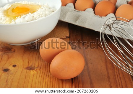 Natural organic brown eggs on a cutting board with a bowl of baking mix