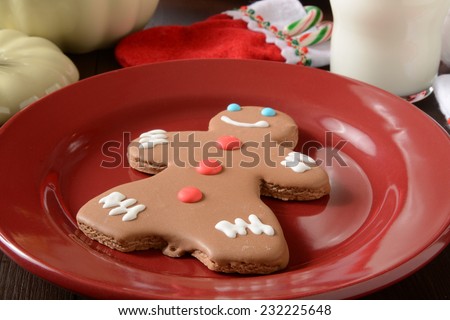 A gingerbread man cookie with candy canes and a glass of milk