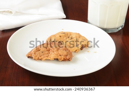 A plate of partially eaten cookies with a glass of milk