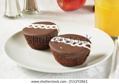 Cream filled chocolate cupcakes with a glass of orange juice