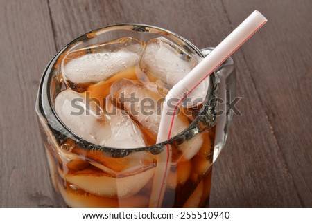 Close up of a root beer or cola in a mug with a straw
