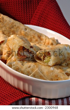 A dish of eggrolls on a red cloth napkin