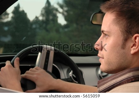 A young man driving his car into the late afternoon sun