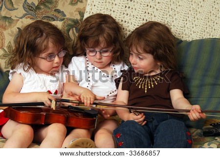 Triplets playing with a violin