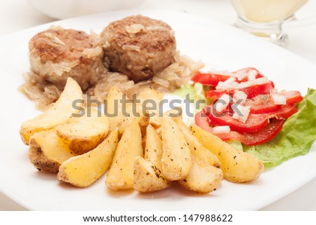 Meatballs with stewed onion and fried potato wedges