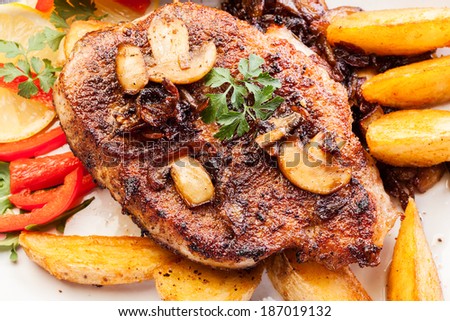 Fried pork chop with mushrooms and chips  on a plate