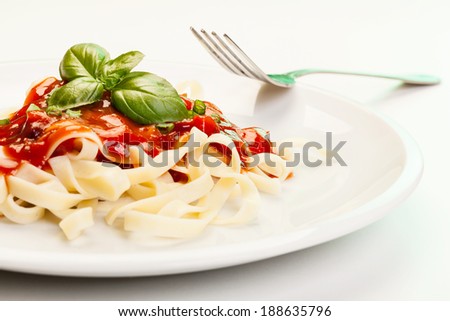 Pasta fettuccine with tomato sauce and basil on a plate
