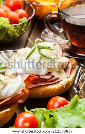 Eggs Benedict on toasted muffins with ham and sauce