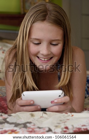 a young girl playing a game or texting on a mobile phone