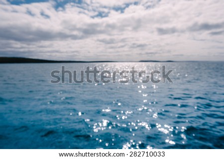 out of focus blurry image of ocean with sparkling sunlight