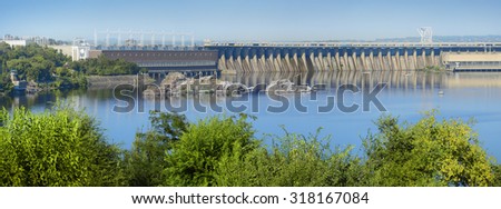 Zaporozhye, 2015 July 9. Dneproges - largest hydrostation PSP, pumped storage plant line on Dnipro. Summer panoramic view from island Hortitsa with space for text on blue sky