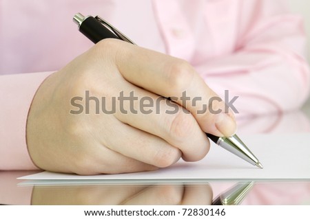 person with pen in hand writing on the page and reflection