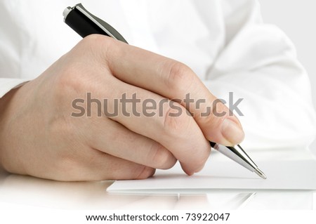 hand with pen of person in white shirt writing on the white page and reflection