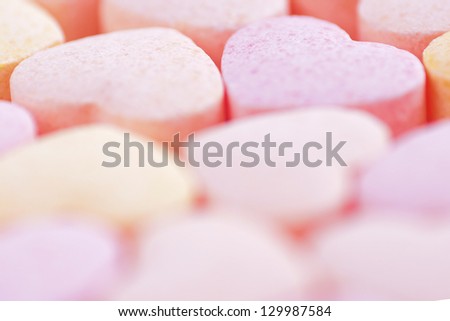 Sweet hearts shaped pink and orange Sugar Pills on white background. Soft Focus.