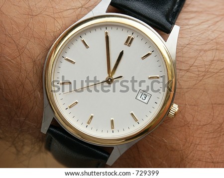 Closeup of Wrist Watch with white face. Hands on Five to Twelve... Calendar - 13.