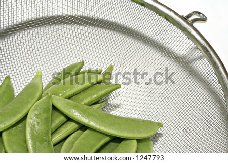 Sugar snap (Mange tout) in a sieve ready to be washed (close up)