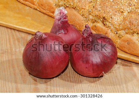 Spring onions, onions, vegetables on a wooden chopping board