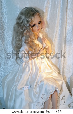 KIEV, UKRAINE - FEBRUARY 26: A collectible doll, which resembles a portrait of small girl in white dress, is on display at the Fashion Doll International exhibit on February 26, 2012 in Kiev, Ukraine.