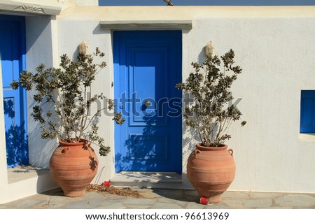 Dark blue door and amphoras with bushes. Mikonos, Greece