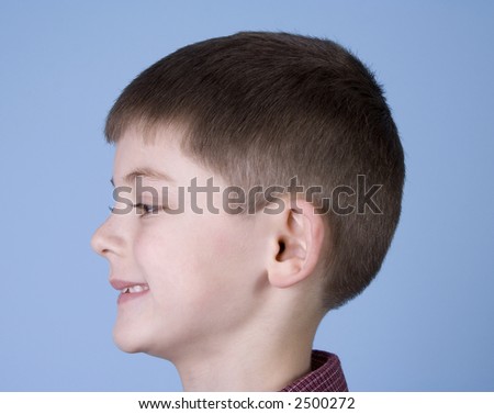 Young Boy Head Shot Smiling Side Profile With Blue Background. Stock ...