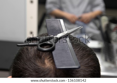 scissors with a comb in the hair salon