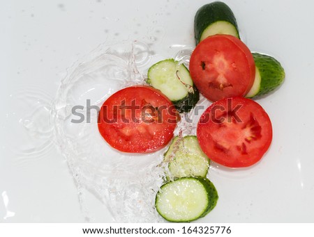 cucumber and tomato in water on white background