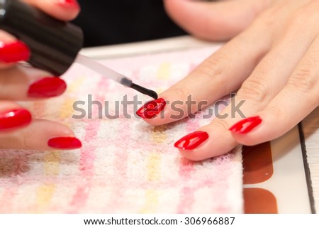 nails painted red nail polish in a beauty salon