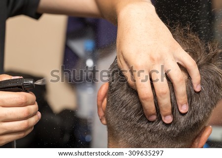 spraying with hair spray in beauty salon
