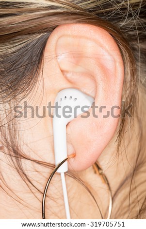 White Earphones in a Girl\'s Ear