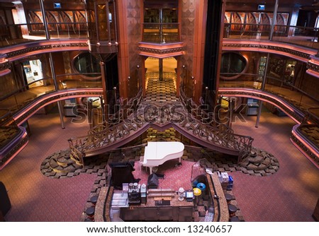 Beautiful multi-level atrium on cruise ship with piano, elevator, and dual stairs