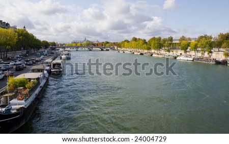 Seine River on a beautiful Fall day with boats and trees along the banks of the river in Paris, France