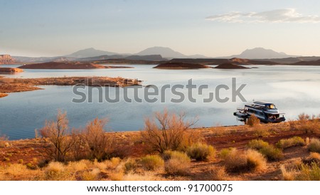 Beautiful desert sunrise scene with houseboat at Lake Powell in Glen Canyon National Recreation