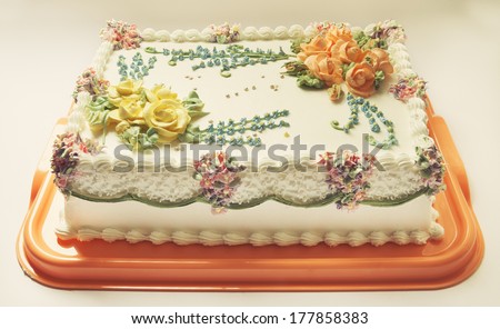Classical birthday cake design with a lot of flowers of cream.