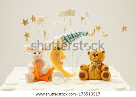 Birthday cake decoration, bear, moon and rabbit made of sugar, put on top of cake.