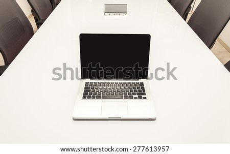 Modern laptop on white table, details of an office interior.
