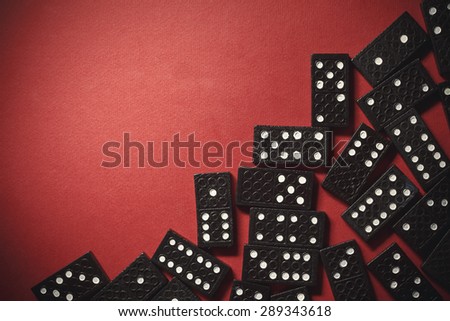 Background composition with black plastic dominoes on one side and empty part on other side.