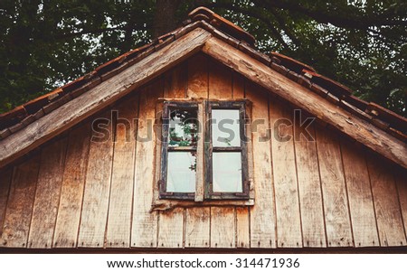 Details of an old wooden house, view on window and part of a roof.