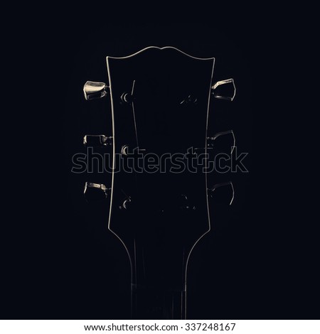 Similar – Image, Stock Photo A black guitar head with the golden tuning pegs and the plastic and metal sides attached to the white screws. A small part of the fingerboard is still visible.