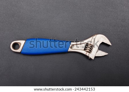 Adjustable wrench tool with blue handle on black