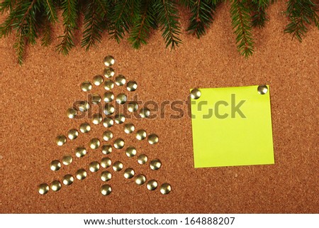 Thumb tacks in shape of Christmas tree on cork board