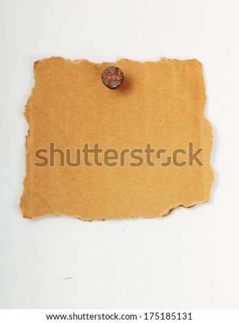 Empty cardboard signboard with nail, hammered in wooden wall, painted with white color