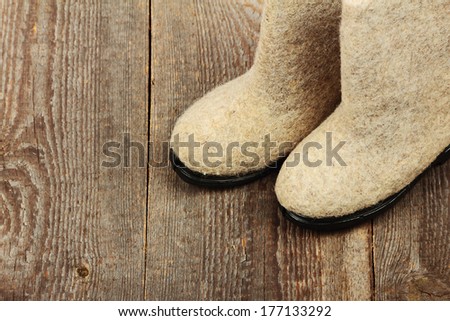 Russian traditional winter felt boot valenki on wooden background. Stock photo