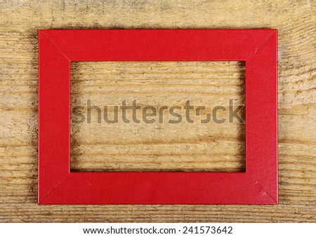 Red empty frame on old wooden background