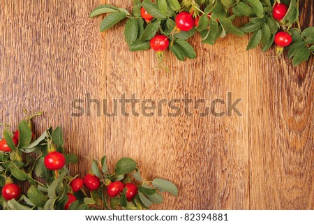 Dogrose on brown wooden fence. Beautiful village background. Horizontal image