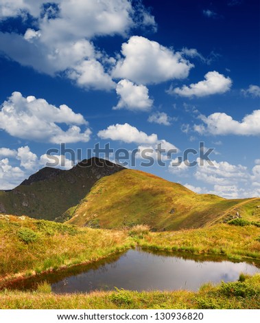 Bright sunny summer landscape with a lake in the mountains.