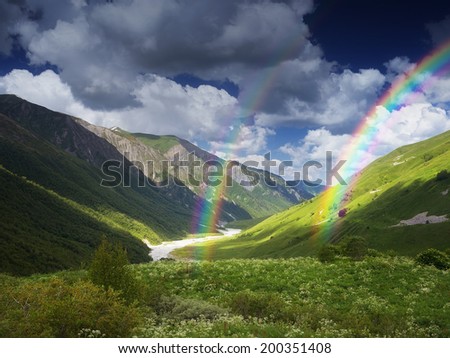 Summer landscape with river in a mountain valley. View from the beautiful sky and rainbow above the mountains