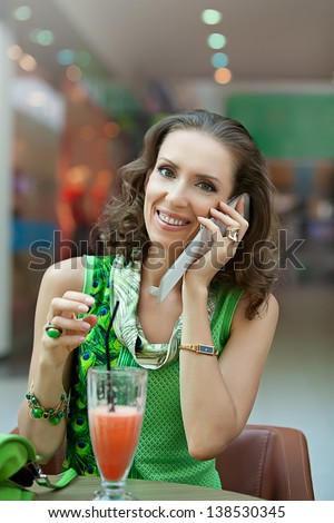 Woman talking on a cell phone in a cafe