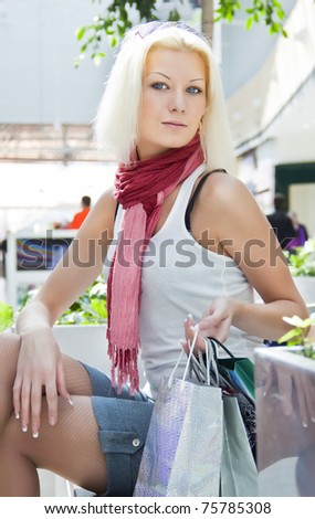 Portrait of woman at the mall with bags, which sat down to rest copyspase